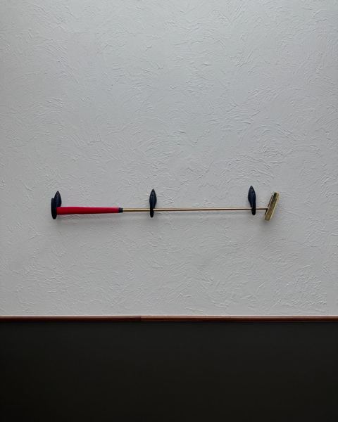 The full putter laid flat against a white wall